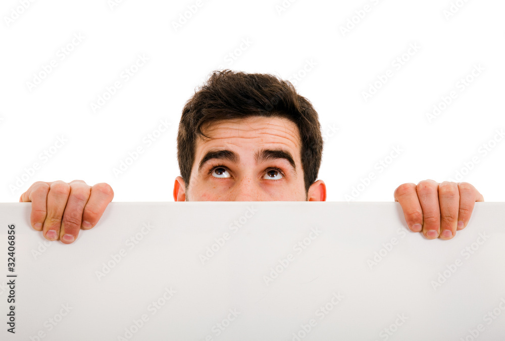 Portrait of a young man looking up and holding blank white card Portrait of a young man looking up and holding blank white card