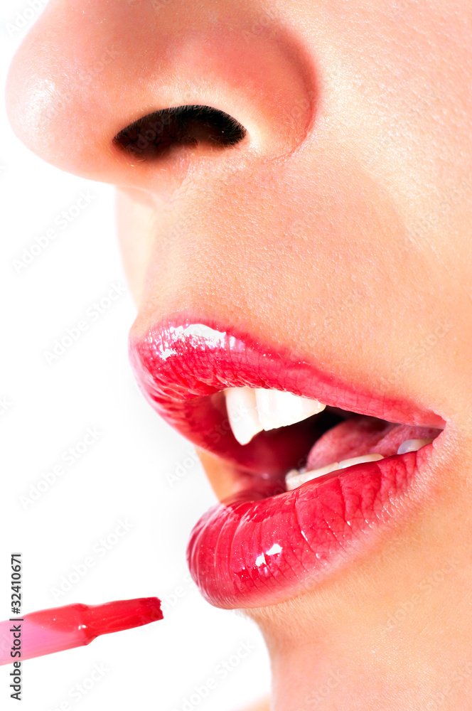 Obraz premium Close up of a girl with opened mouth, putting makeup on