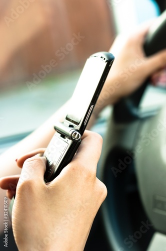 A phone in the hand os a woman who is driveing