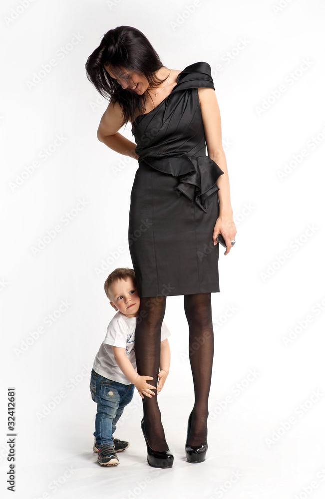 Little boy clinging to mother's leg unwilling let her go