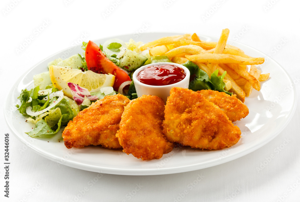 Fried chicken nuggets, French fries and vegetables Fried chicken nuggets, French fries and vegetables