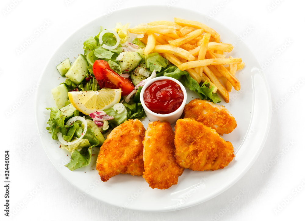 Fried chicken nuggets, French fries and vegetables Fried chicken nuggets, French fries and vegetables