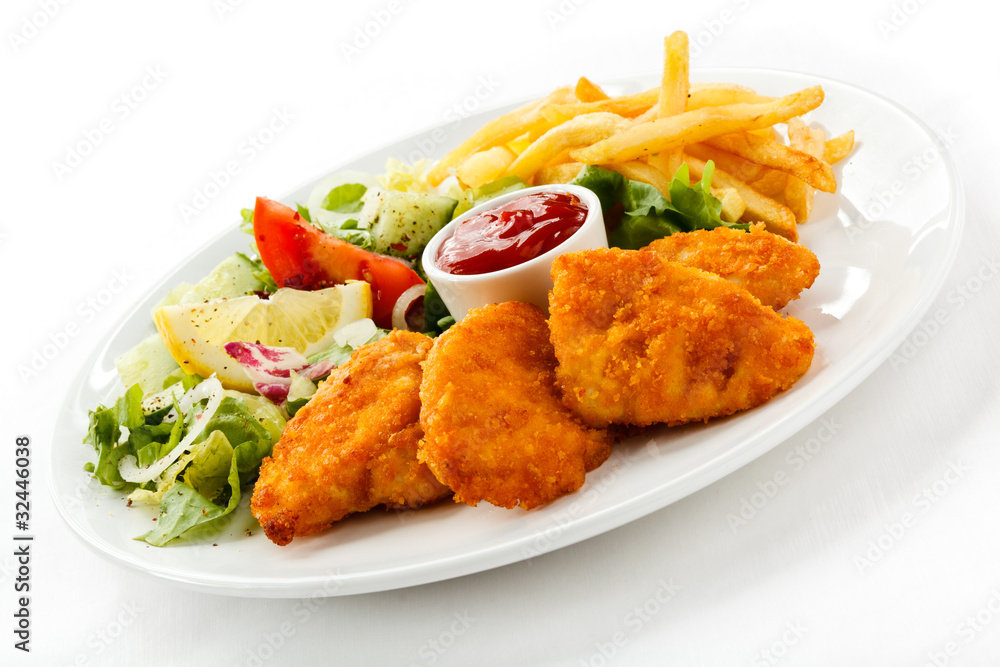 Fried chicken nuggets, French fries and vegetables Fried chicken nuggets, French fries and vegetables