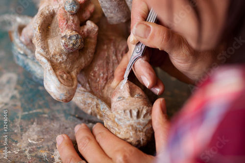 restaurateurin bearbeitet alte statue mit skalpell