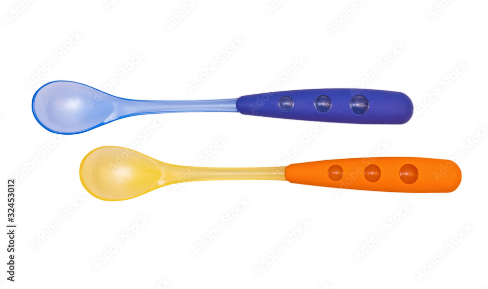 Blue and orange bright children's spoons on the white Blue and orange bright children's spoons on the white