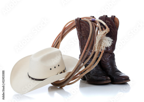 Cowboy hat, boots and lariat on white