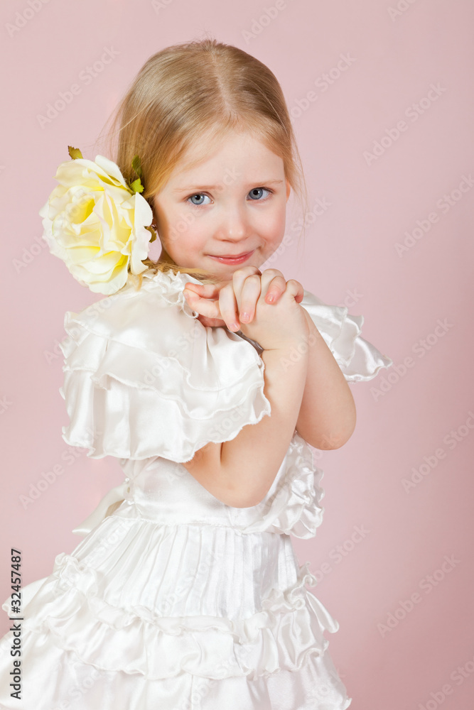 child in a white dress with a flower in hair child in a white dress with a flower in hair