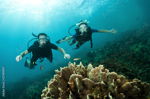 man and woman scuba dive together