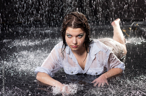 Fotografie beautiful girl in the rain against a dark background