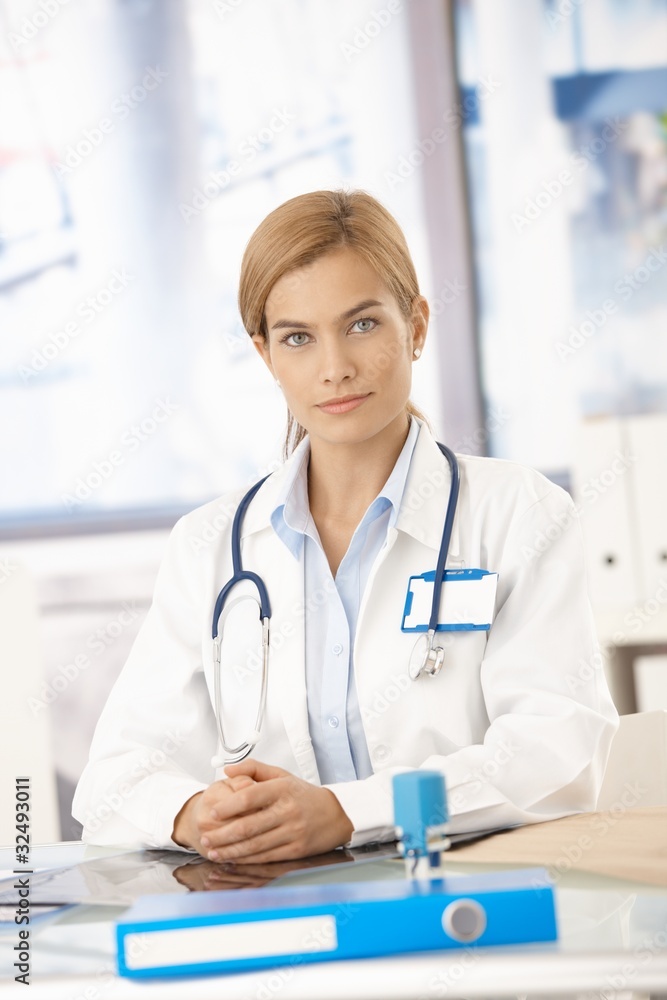 Young female doctor sitting at desk Young female doctor sitting at desk