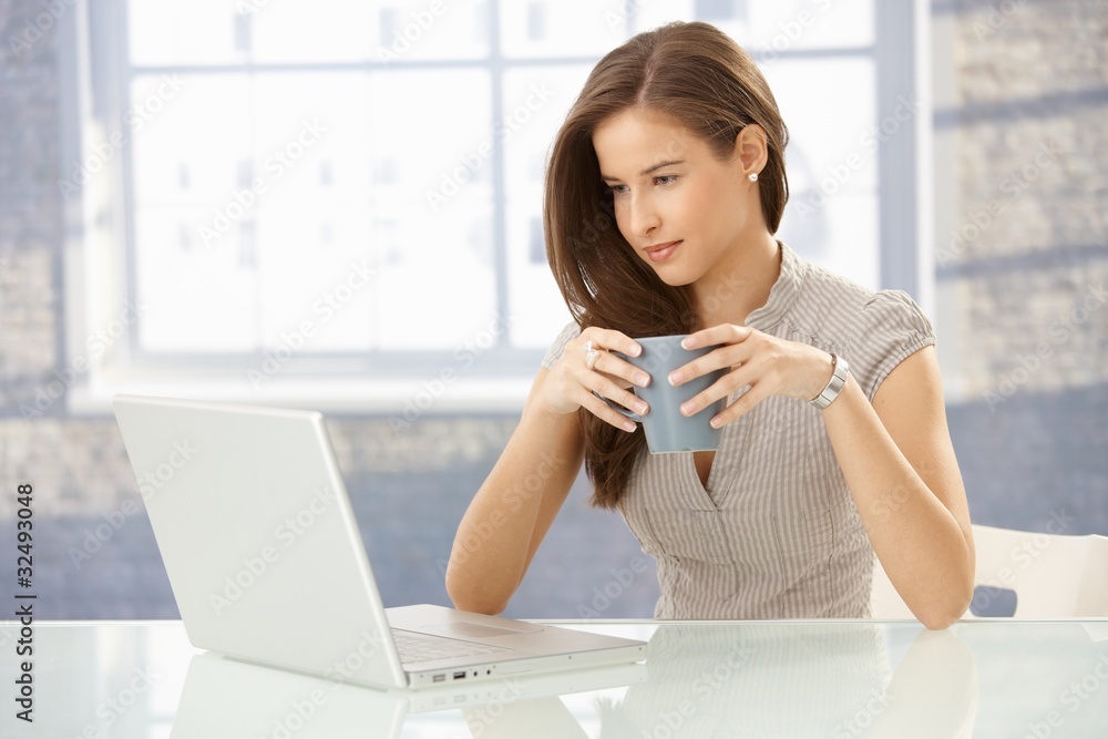 Businesswoman with laptop having tea Businesswoman with laptop having tea
