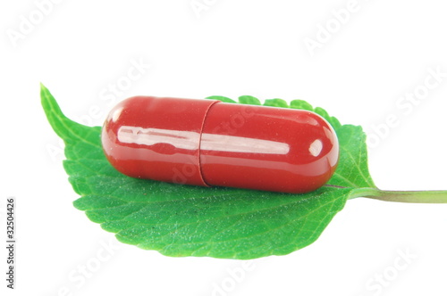 kapsułka ziołowa na liściu bazylii czerwonej