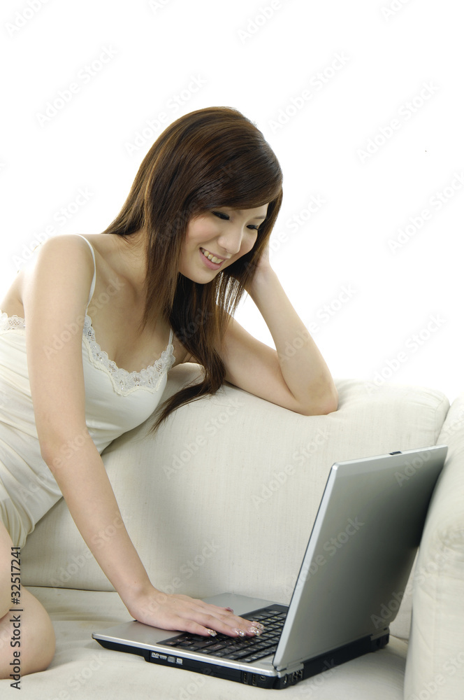Beautiful young smiling woman with laptop on the sofa Beautiful young smiling woman with laptop on the sofa