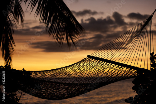 silouhette of hammock on beach overlooking ocean at sunset