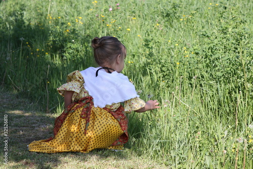 Photos petite fille en robe provençale cueillant des fleurs