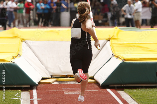 Female athlete competing in the pole vault photo