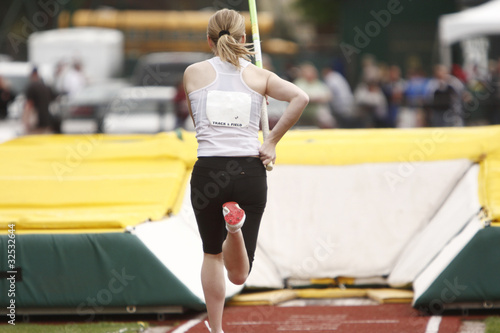 Female athlete competing in the pole vault photo