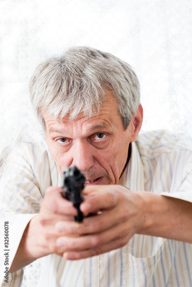 Older angry man aiming with gun and ready to fire Older angry man aiming with gun and ready to fire