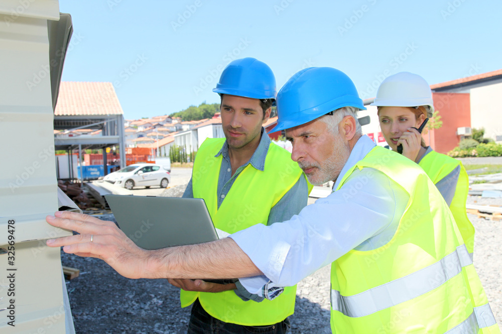 Construction workers checking building structure
