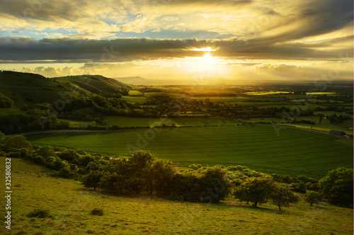 Stunning countryside landscape with sun lighting side of hills a