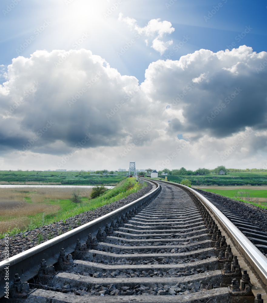 railway to horizon under cloudy sky