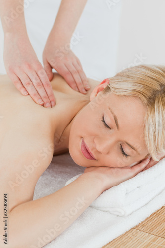 Closeup of young attractive woman receiving a back massage