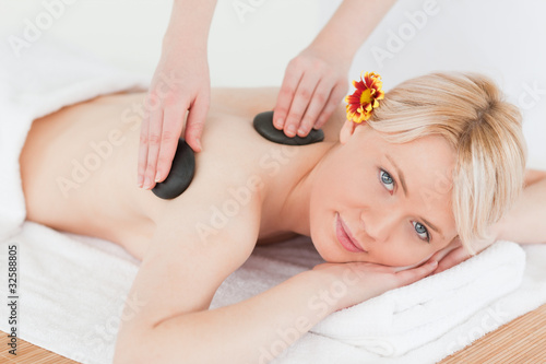 Cute woman receiving a massage with hot stones