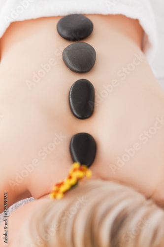 Blonde woman relaxing with hot stones on her back