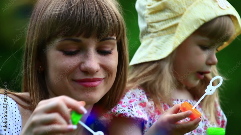 Mother and daughter blowing air bubbles Mother and daughter blowing air bubbles