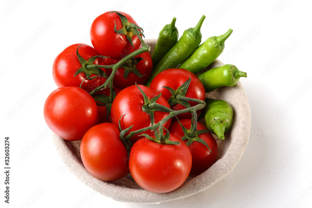 Red tomatoes and green peperoni in basket Red tomatoes and green peperoni in basket