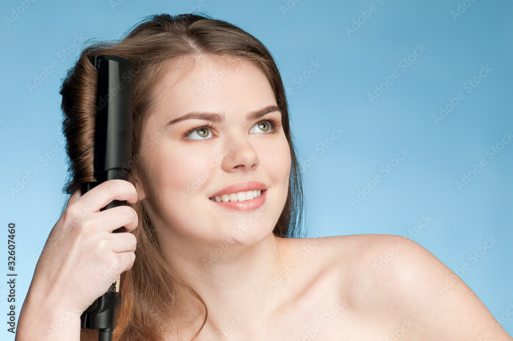 Close up portrait of young woman with hair iron Close up portrait of young woman with hair iron