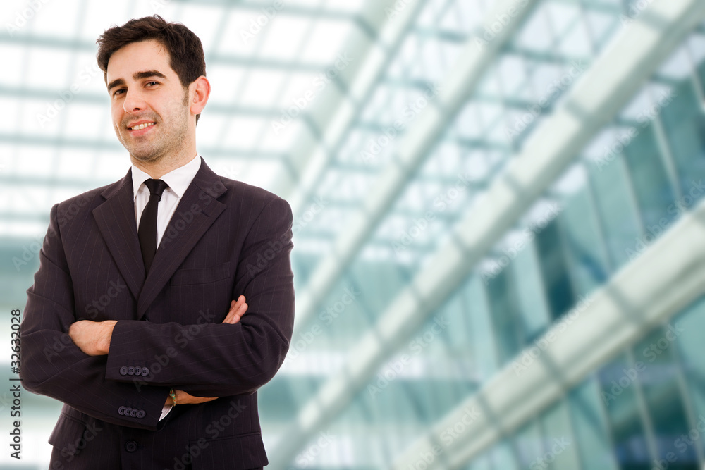 Closeup of a young smiling business man standing at modern offic Closeup of a young smiling business man standing at modern offic