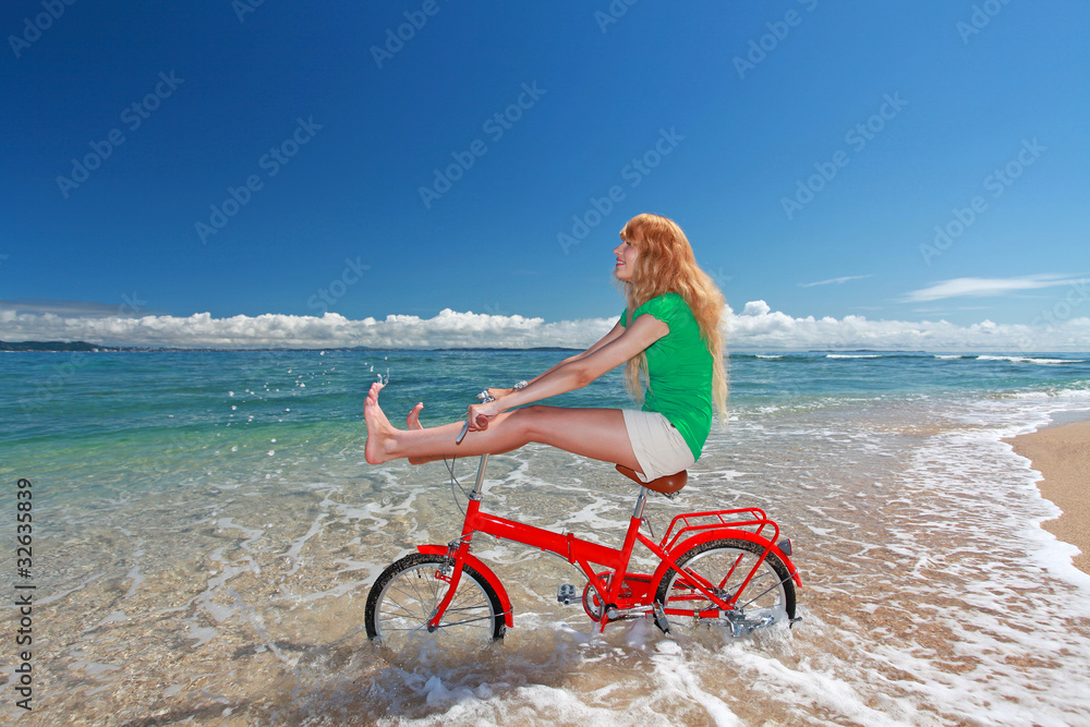 久高島の美しいビーチで自転車に乗りはしゃいでいる女性 久高島の美しいビーチで自転車に乗りはしゃいでいる女性