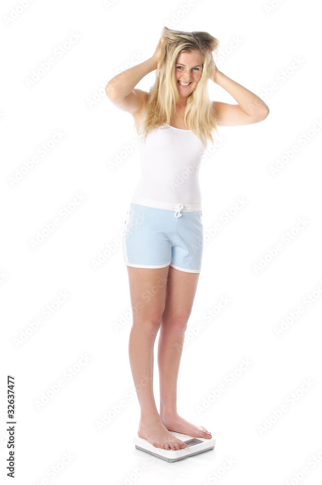 Hübsche Frau auf der Waage rauft sich die Haare Hübsche Frau auf der Waage rauft sich die Haare