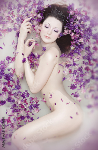 Obraz na płótnie Attractive naked girl enjoys a bath with milk and rose petals. w salonie