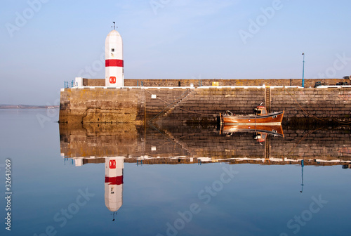 Old Lighouse and Boat with Sea Water Replection photo