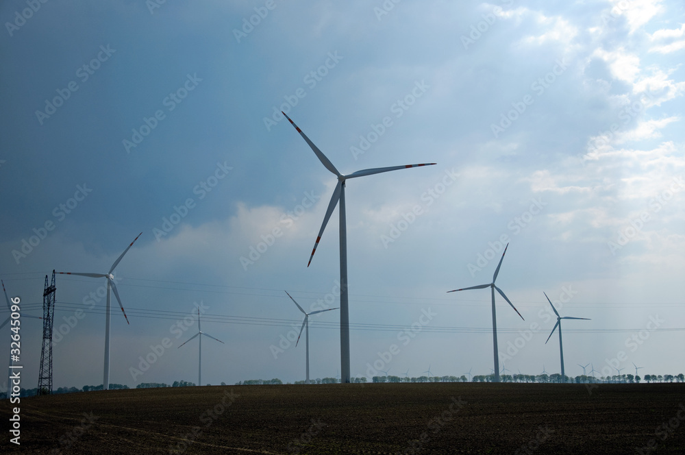 Wind turbines farm on sunset in summer