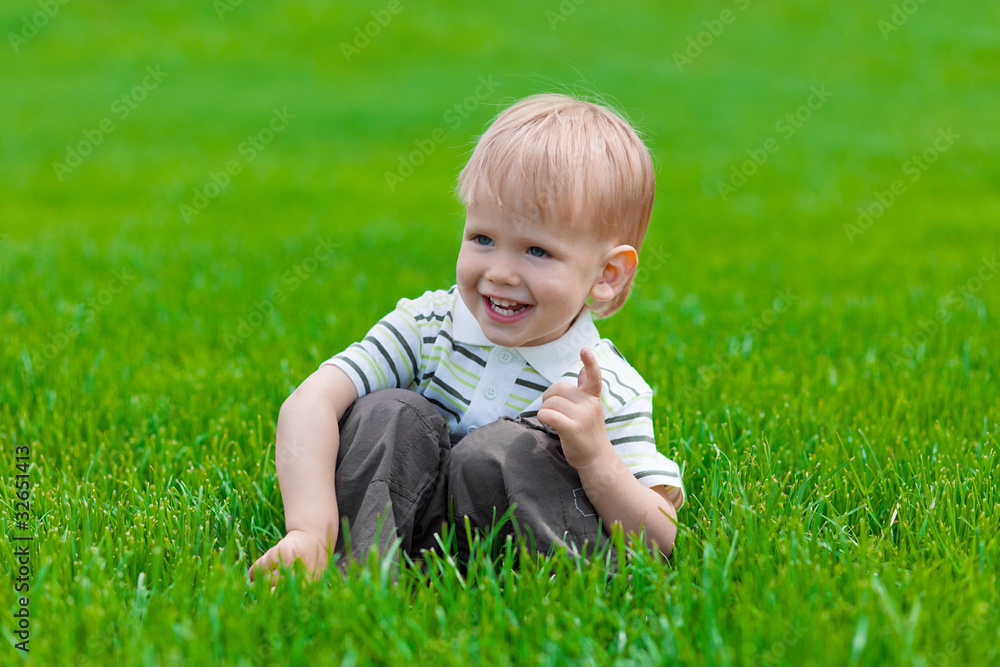 Little boy sitting and dreaming in green grass Little boy sitting and dreaming in green grass
