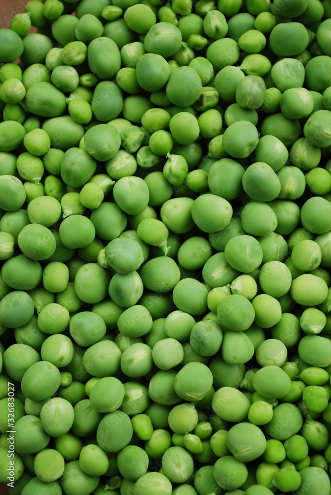 Shelled fresh ripe sweet green peas background, vertical Shelled fresh ripe sweet green peas background, vertical