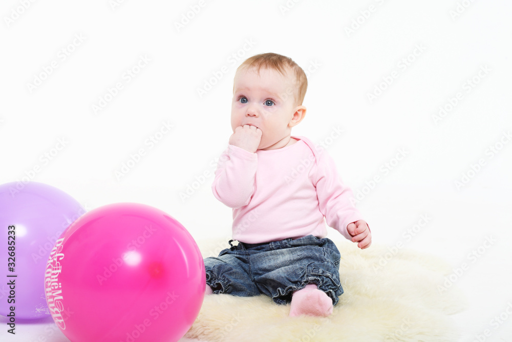 girl in a pink jacket and jeans with multi-colored balloons. girl in a pink jacket and jeans with multi-colored balloons.