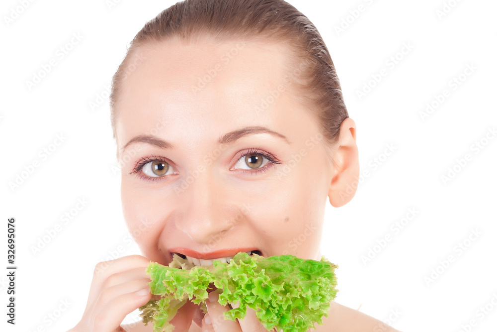 Pretty model holding a lettuce leaf close to lips Pretty model holding a lettuce leaf close to lips