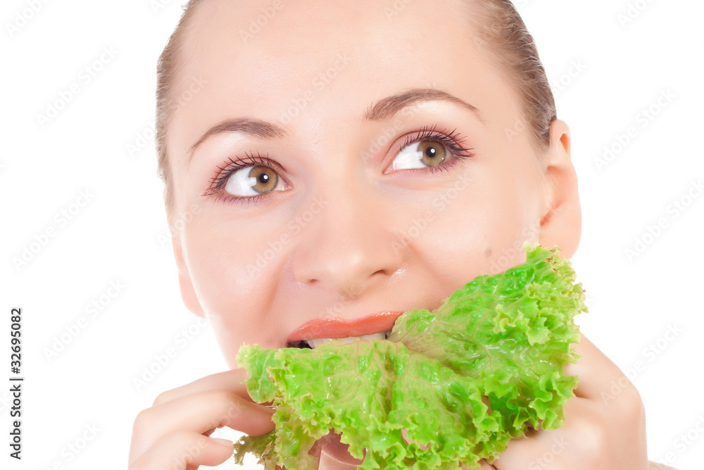 Pretty model holding a lettuce leaf close to lips Pretty model holding a lettuce leaf close to lips