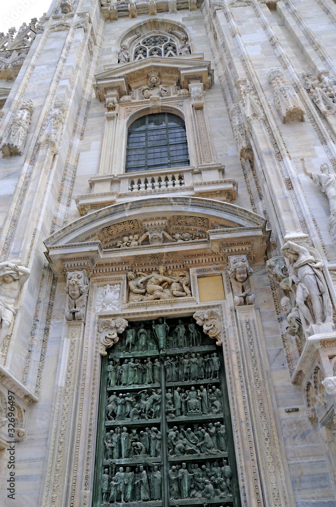 Door in the Gothic facade of the Cathdral in Milan Italy