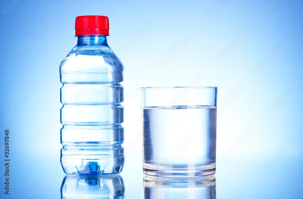 Bottle of water and glass on blue background Bottle of water and glass on blue background