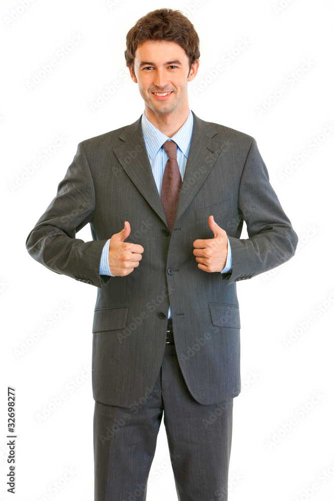 Smiling young businessman showing thumbs up gesture Smiling young businessman showing thumbs up gesture