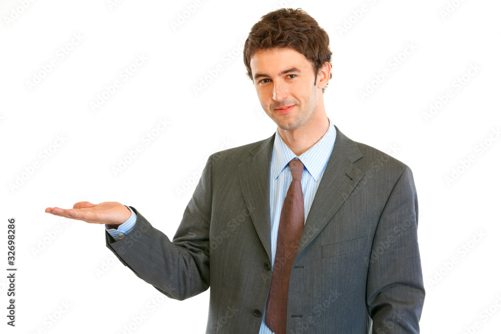 Smiling businessman presenting something on empty hand Smiling businessman presenting something on empty hand