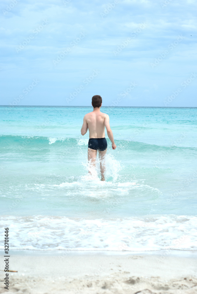 Happy man running into the ocean Happy man running into the ocean