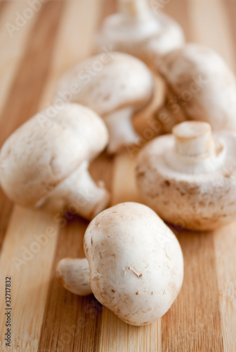 heap of tasty champignons on a wooden brown board