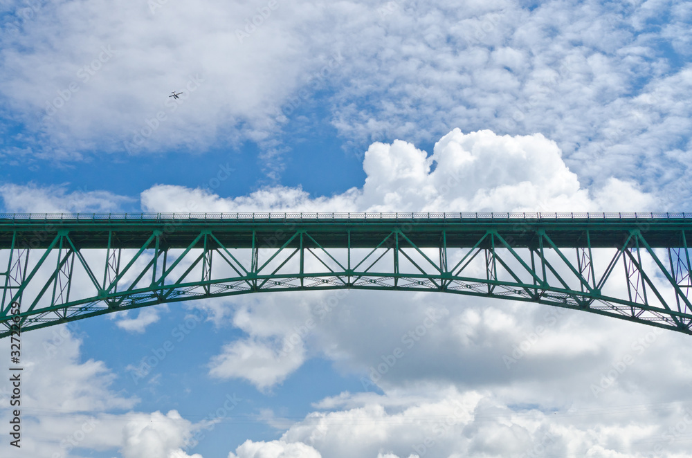 Fototapeta premium Bridge in the blue sky over white clouds