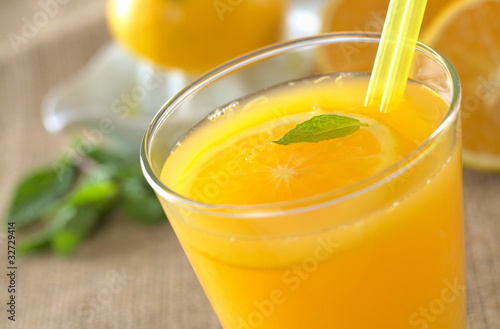 Freshly squeezed orange juice with orange slice, mint leaf